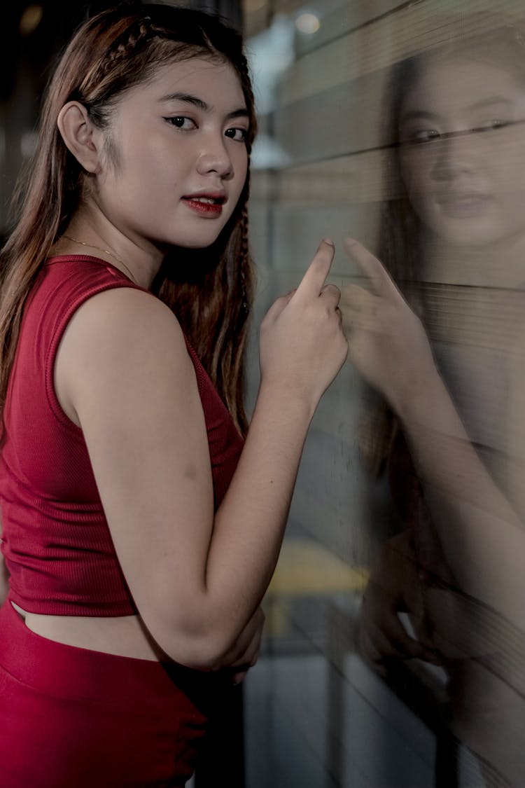 Woman In Red Outfit Reflecting In Glass