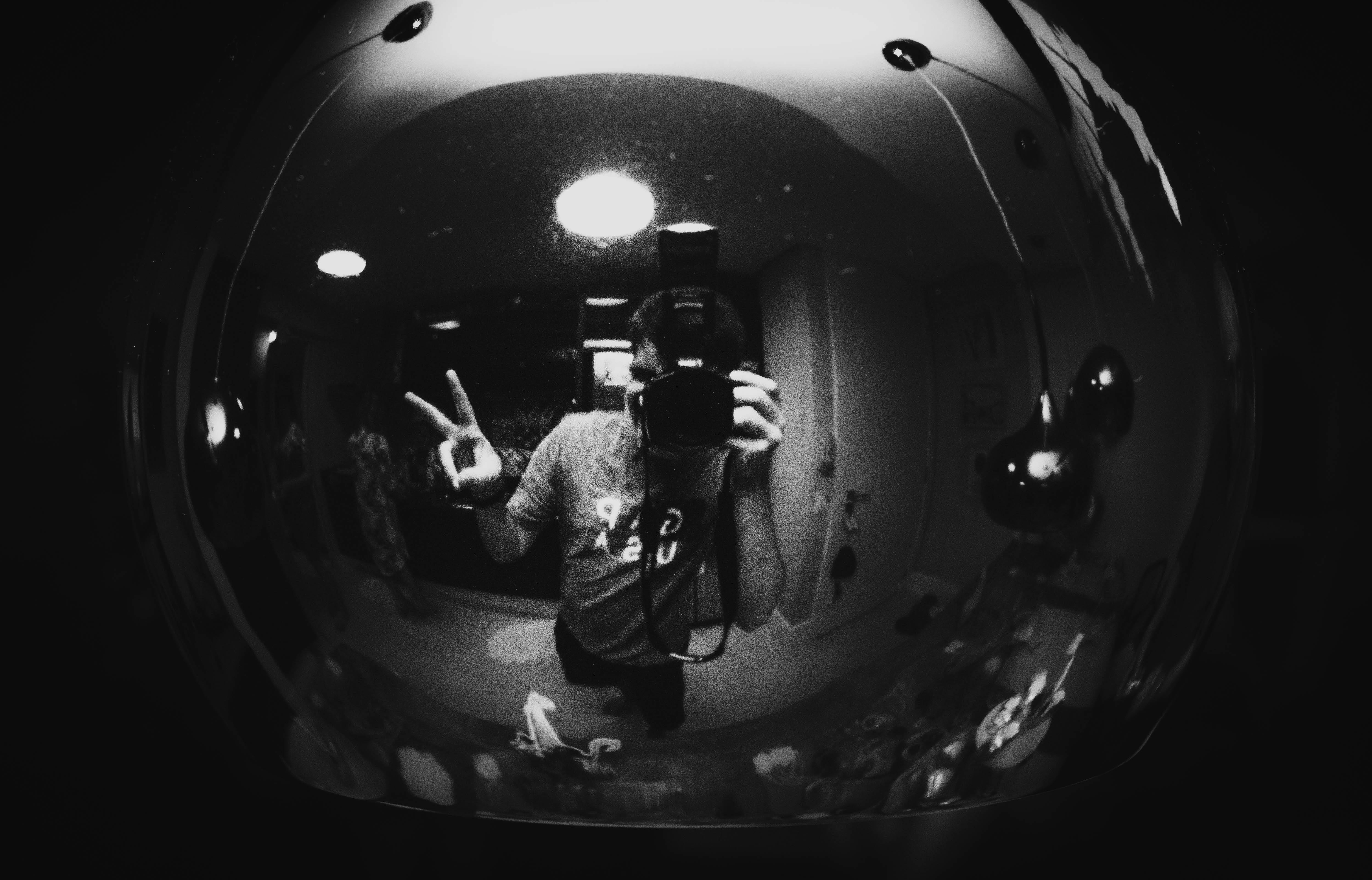 镜面反射捕捉到摄影师手持相机的单色照片