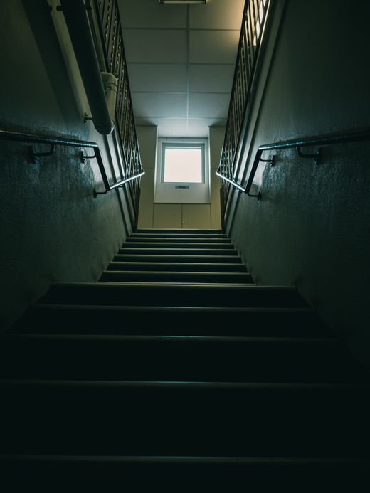 Dark stairwell rising toward a single window — photo by Sonny Sixteen on Pexels