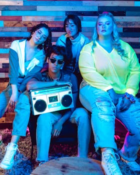 Group of diverse adults in neon lighting, posing with a retro boombox and embracing a vintage 80s aesthetic.