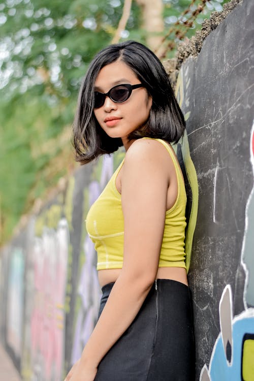 Woman in Sunglasses Posing near Wall Outdoors