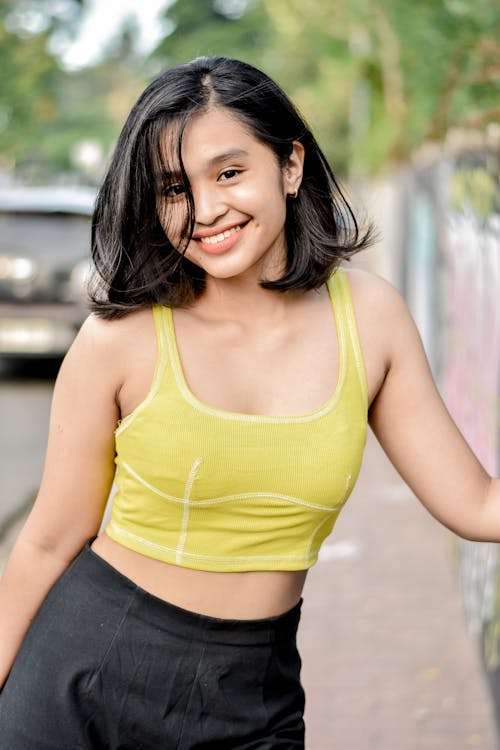 Posed Photo of a Smiling Young Woman in a Yellow Crop Top