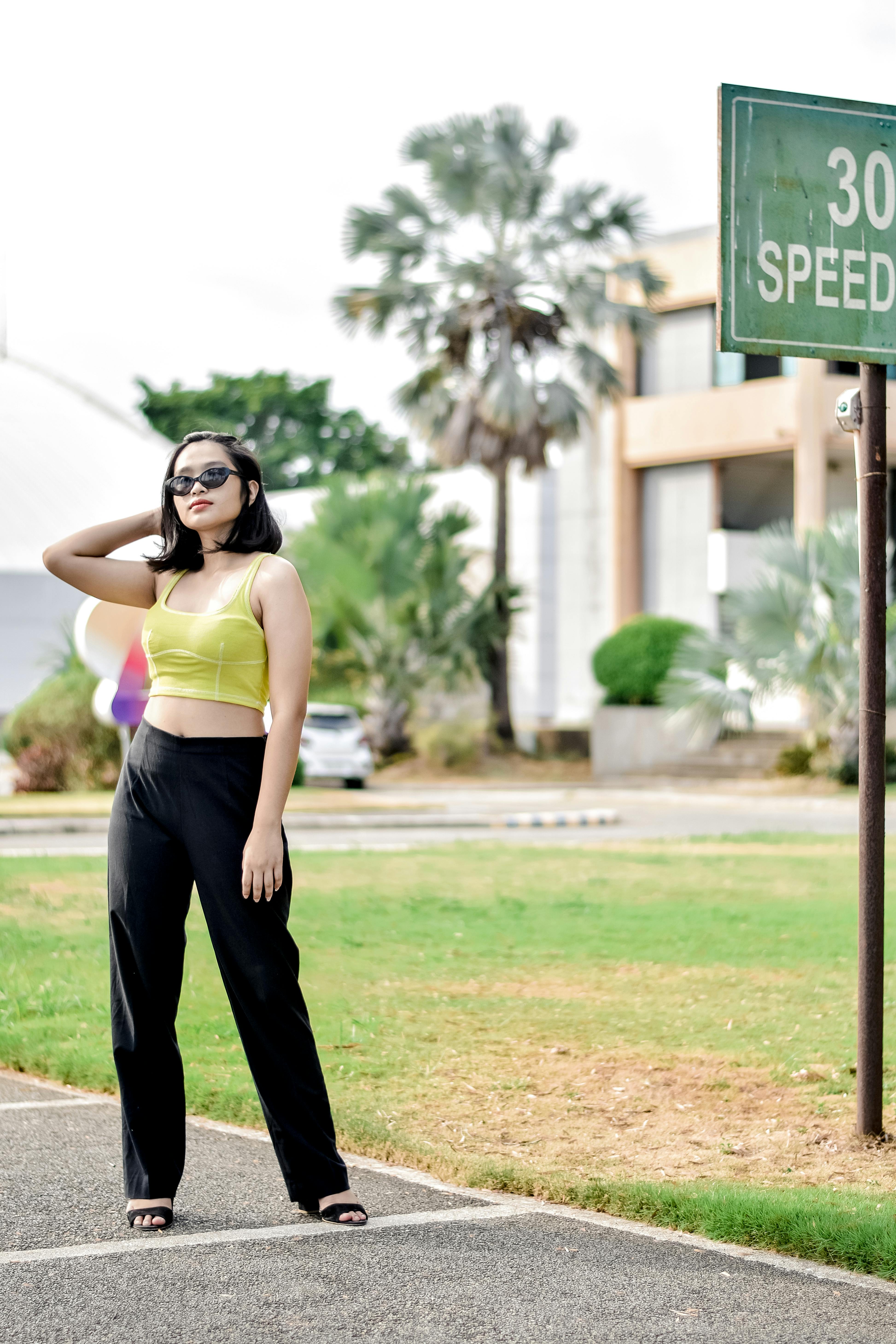 photo of a standing on the street young woman with hand in hair