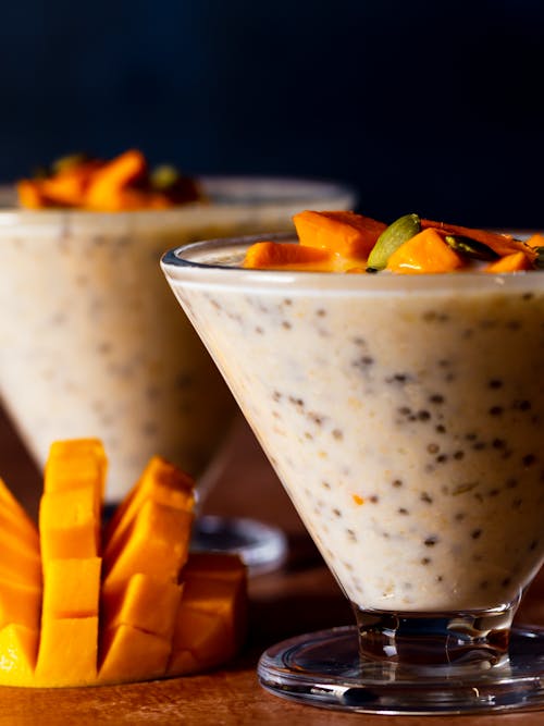 Fruit Dessert Served in Glass next to Cut up Mango