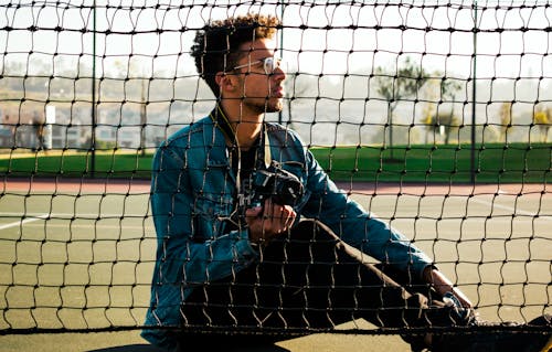 Free Photo of Man Sitting On Tennis Court Stock Photo