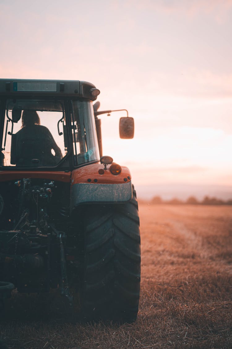 Tractor On A Field At Sunset