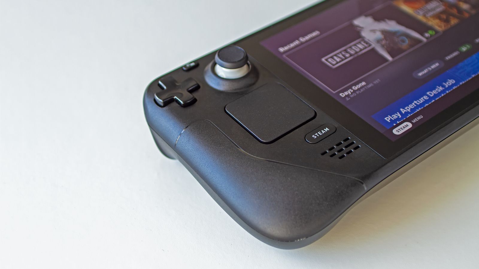 Close-up of a Steam Deck handheld gaming PC showing a game selection screen, a real stock photo with no people in the frame, chosen because Steam Next Fest is about trying free PC game demos on Steam. It is not a screenshot from any game