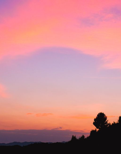 Stunning sunset sky with vivid pink and orange hues over the silhouette of Tirana, Albania.