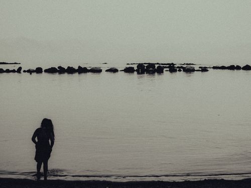 Free A serene silhouette of a woman by the calm seashore in Corfu, Greece, at twilight. Stock Photo