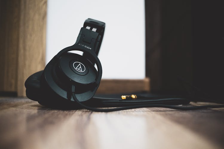 Low Angle Shot Of Black Headphones On A Wooden Floor