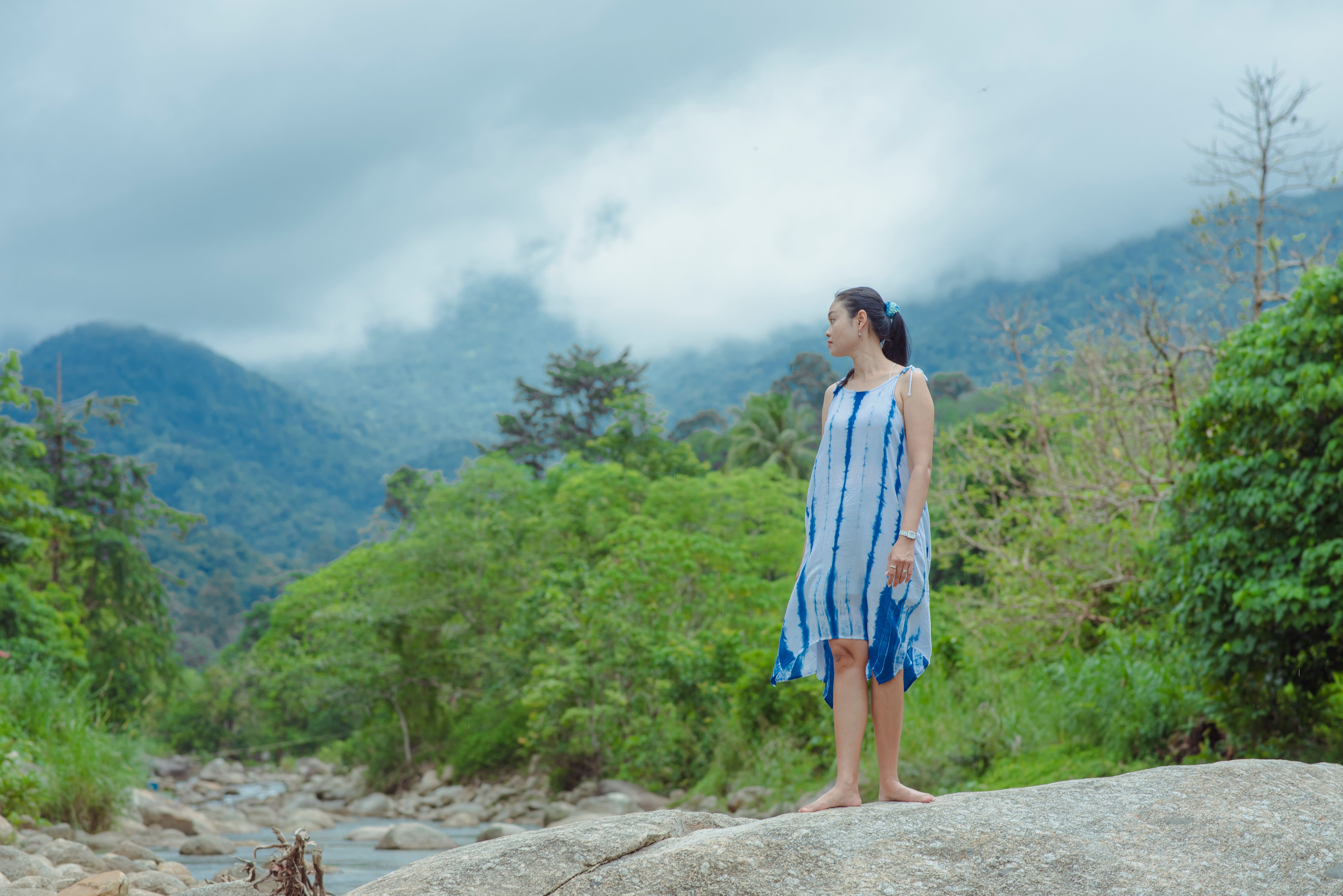 A Woman in Blue Dress Standing on Big Rock while Looking Afar · Free ...