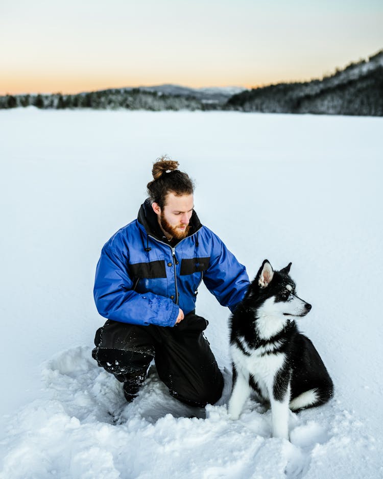 Man With A Husky Dog In A Winter Setting