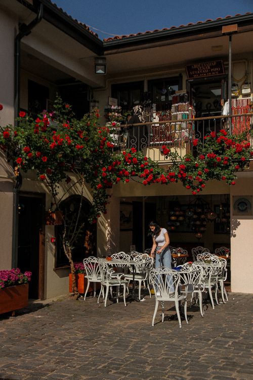 Free A cozy outdoor cafe with vibrant flowers on a sunny summer day, capturing a relaxed atmosphere. Stock Photo