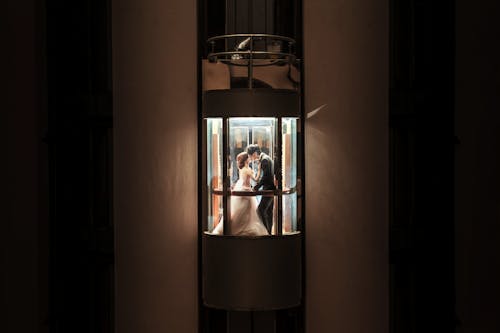 Free Atmospheric Image of Newlyweds Kissing in an Elevator Stock Photo