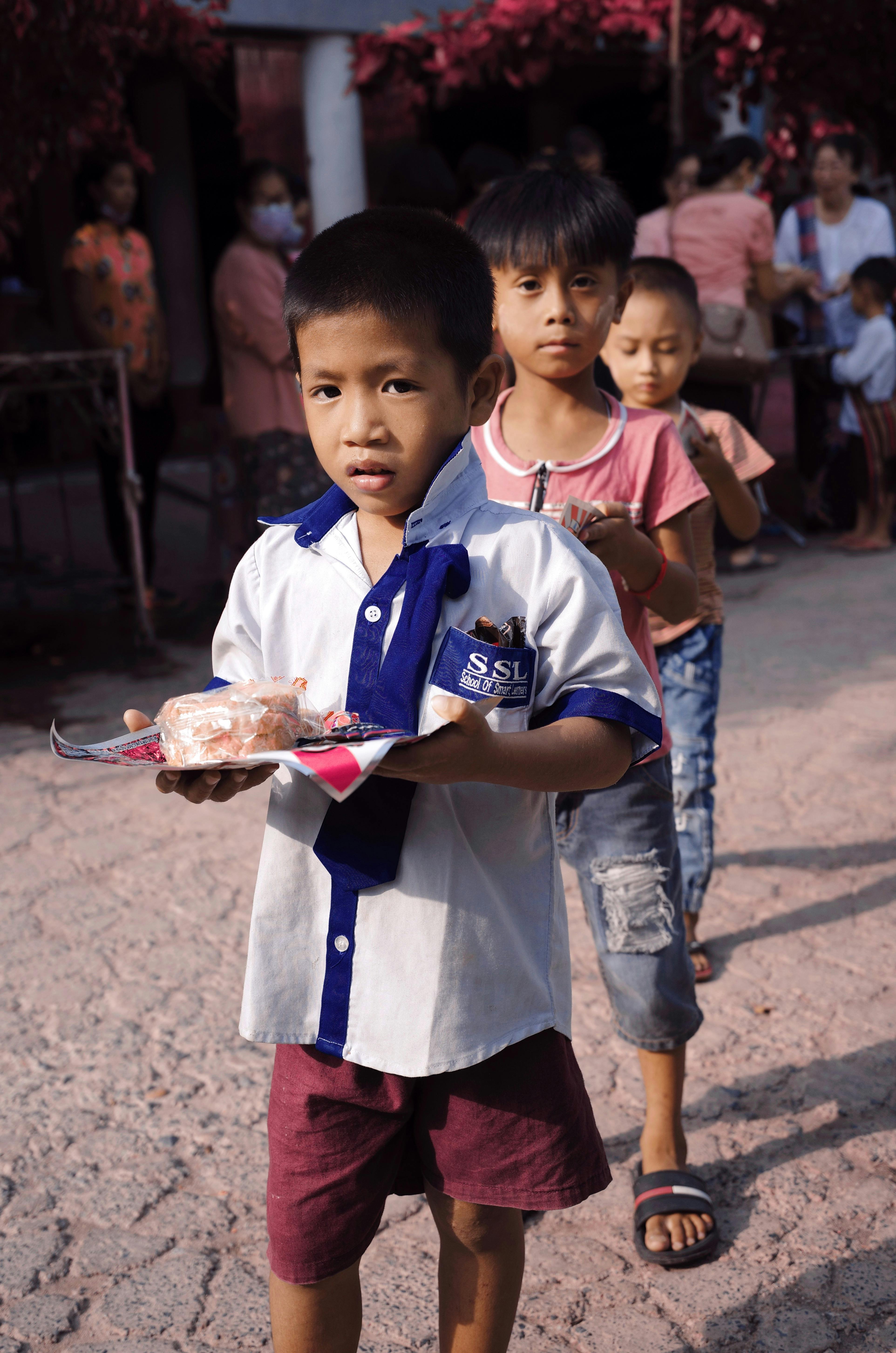 lined up children carrying food