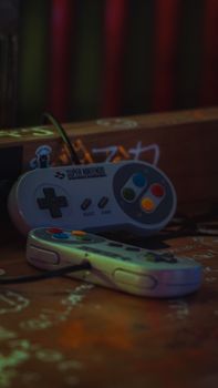 Close-up of vintage Super Nintendo game controllers on a dark surface.
