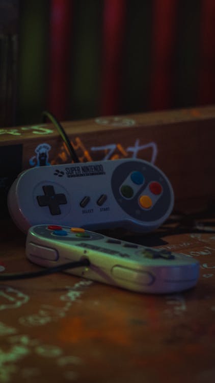 Nintendo Game Controllers on Wooden Surface