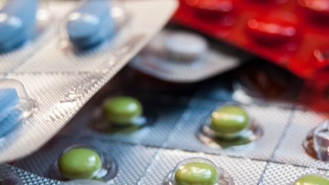 Close-up of various prescription pills in blister packs, highlighting medication diversity.