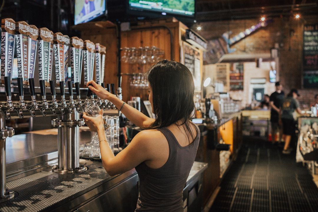 Bartender pulling pints along the row of taps