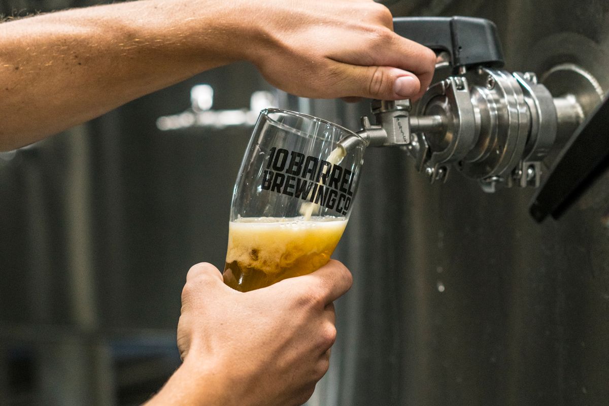Close-up of beer being poured into a glass from a brewery tank