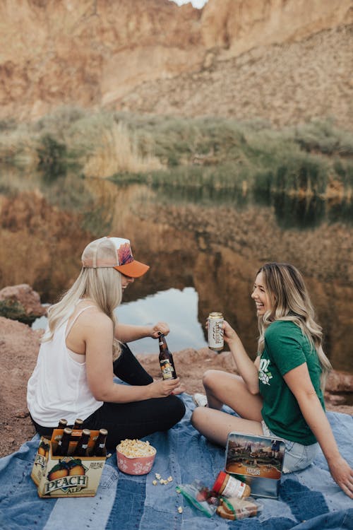 Free ピクニックで白いトップの女性の横に座っている緑のクルーネックtシャツの女性 Stock Photo