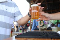 两个人在酒吧柜台前交换刚倒的啤酒