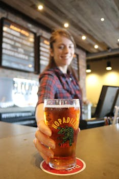 Friendly bartender serving a cold pint of Hopadillo IPA at a cozy bar setting.