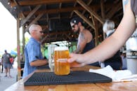 一家热闹的酒吧在户外供应冰镇精酿啤酒，人们是其背景