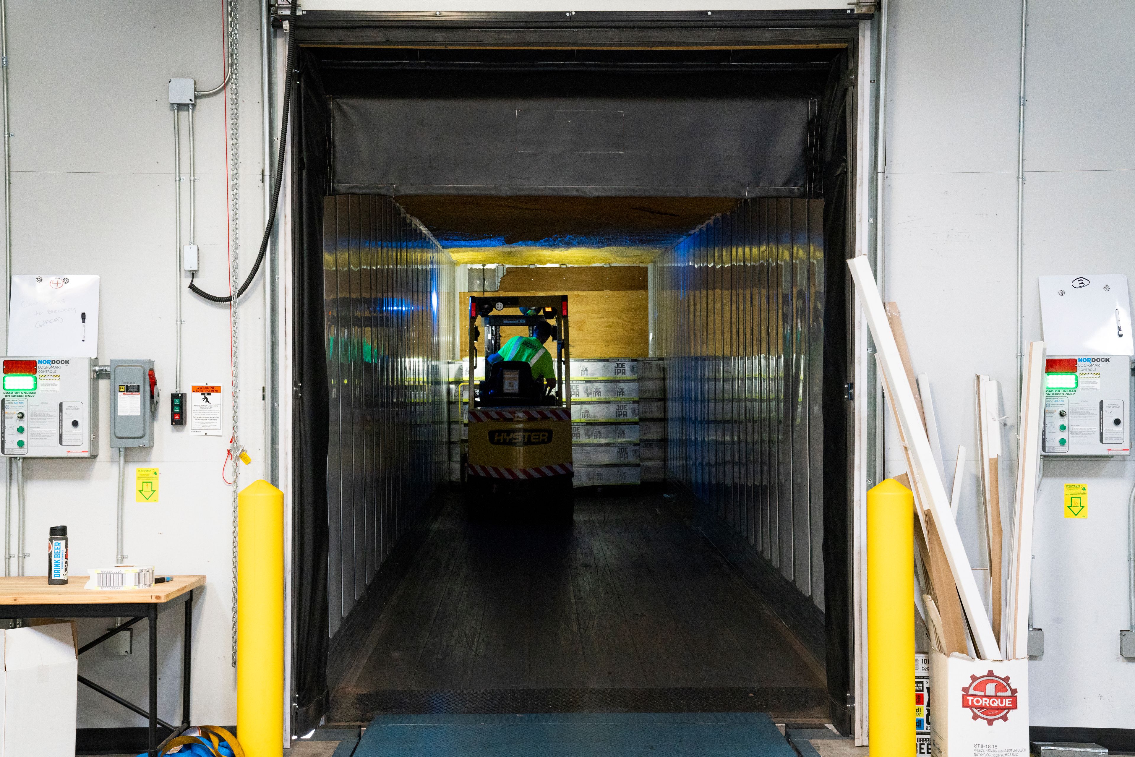 Passage de manutention balisé de jaune, porte sectionnelle ouverte au fond du bâtiment