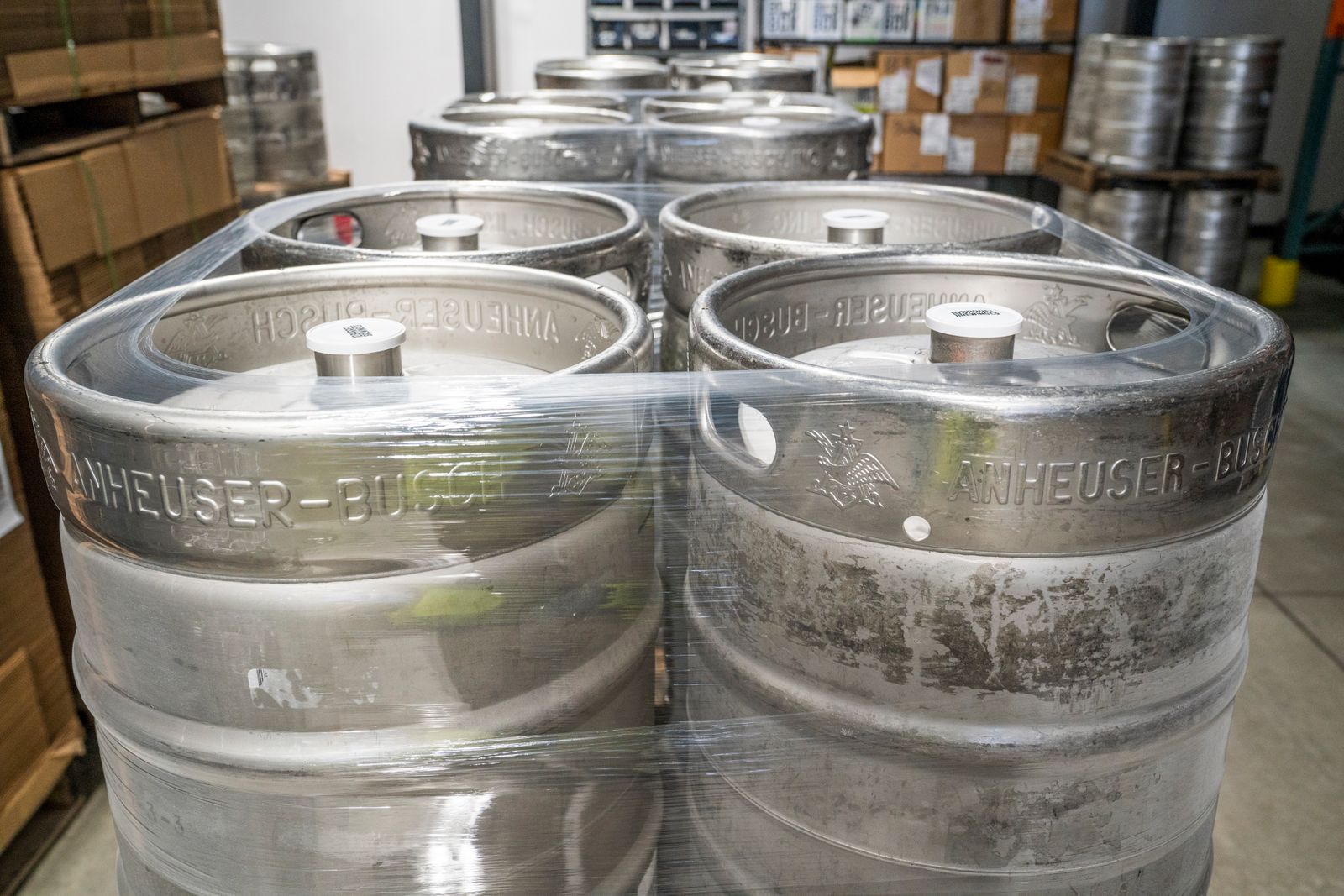 Stacked steel beverage kegs in a warehouse
