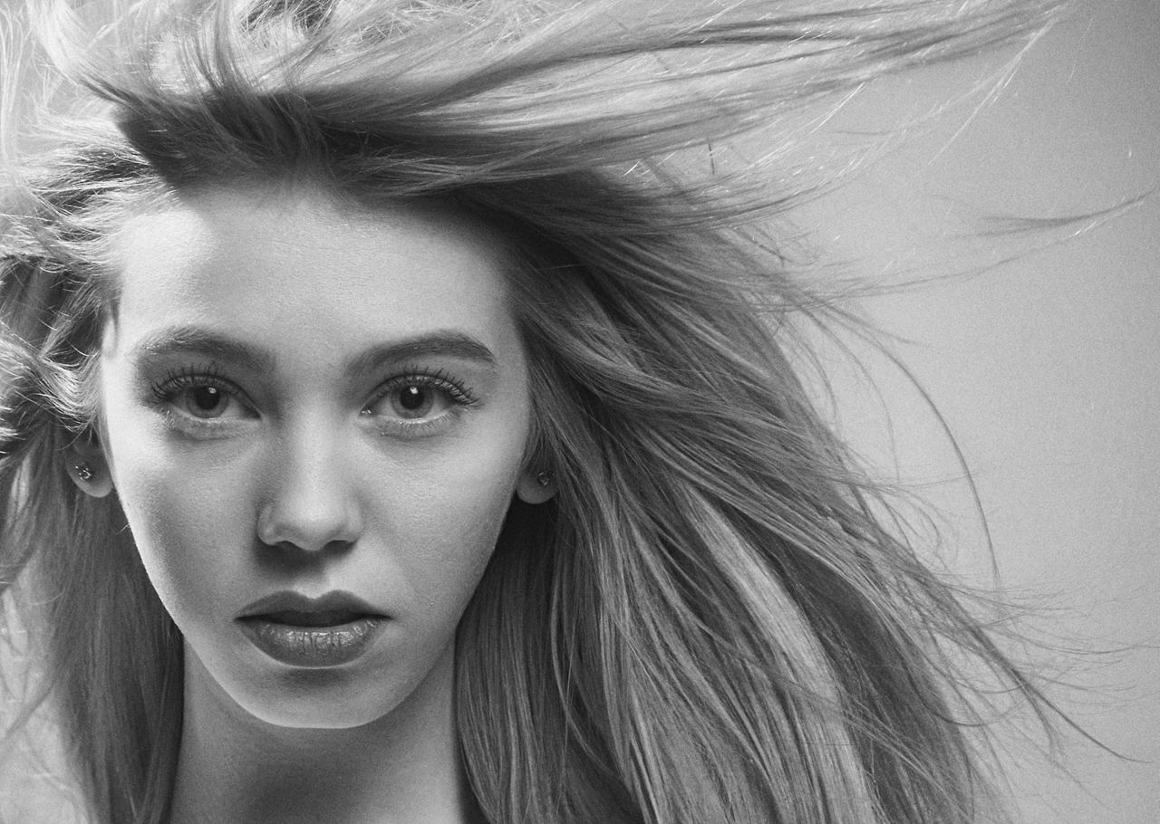 striking black and white portrait of a woman with wind swept hair exud