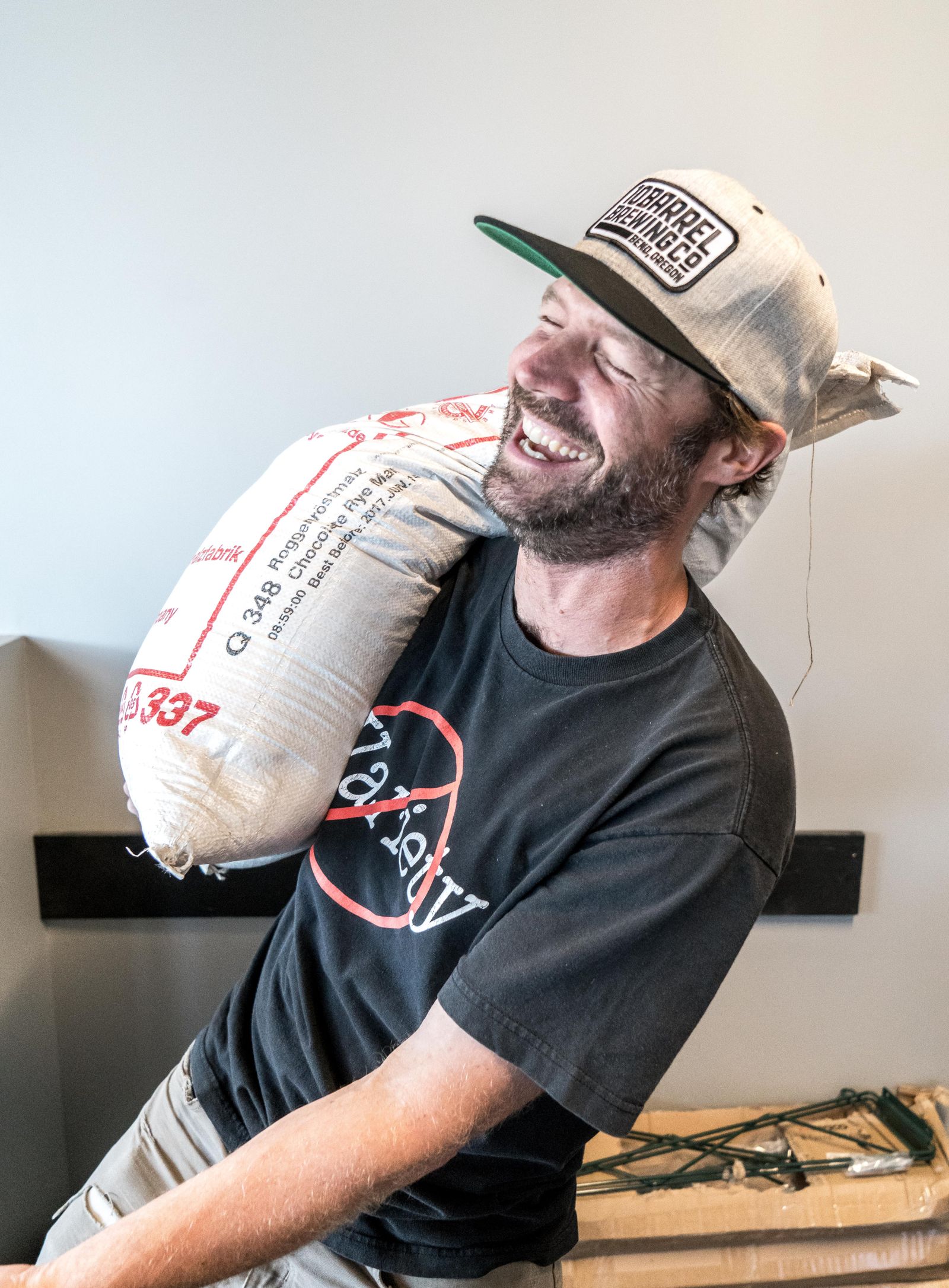 Worker carrying a heavy sack, matching lower-back support decisions for work. Photo: Pexels.