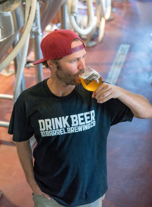 Man Drinking Beer and Looking at His Left Side