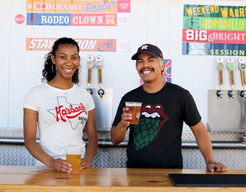 Man and Woman Smiling While Drinking Beers