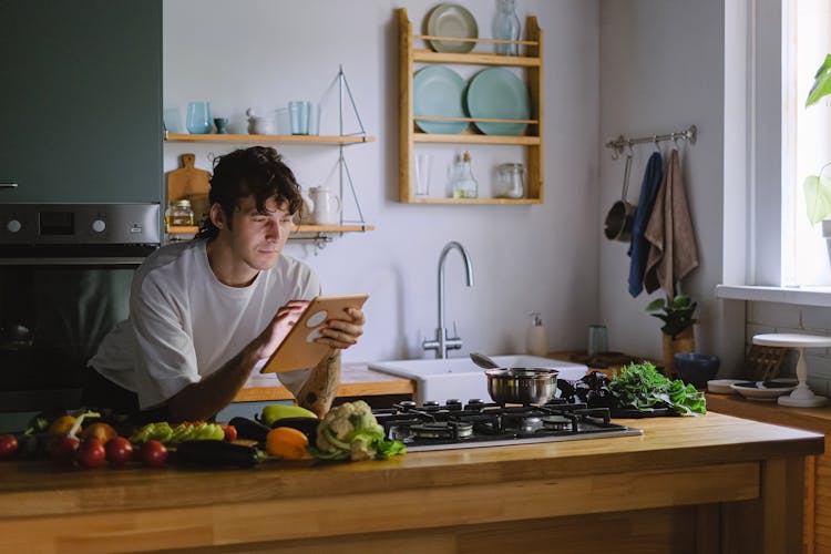 Man Using A Tablet In A Kitchen