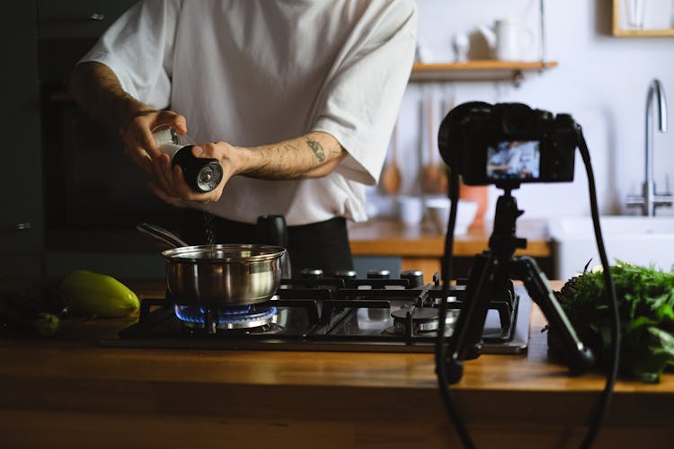 Vlogger Recording Himself Cooking In A Kitchen