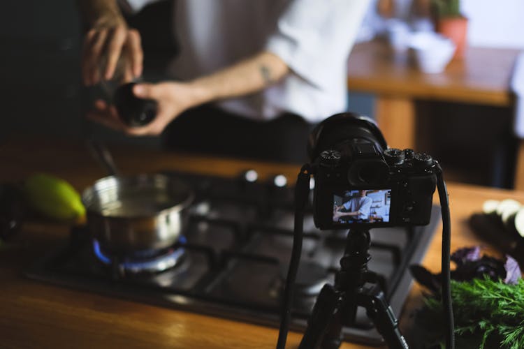 Vlogger Recording Himself Cooking In A Kitchen