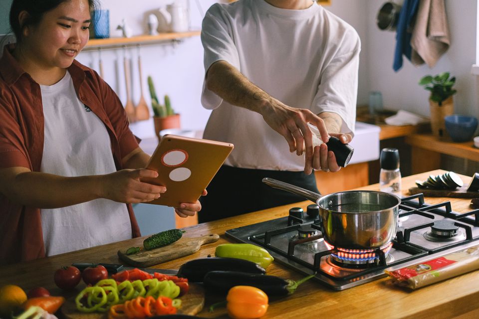 A happy couple cooking together in a kitchen