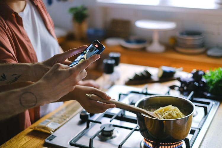 Person Taking A Picture Of Cooking Spaghetti