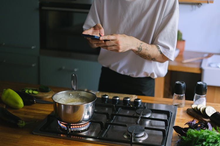 A Person Taking Picture Of A Pot With Boiling Water