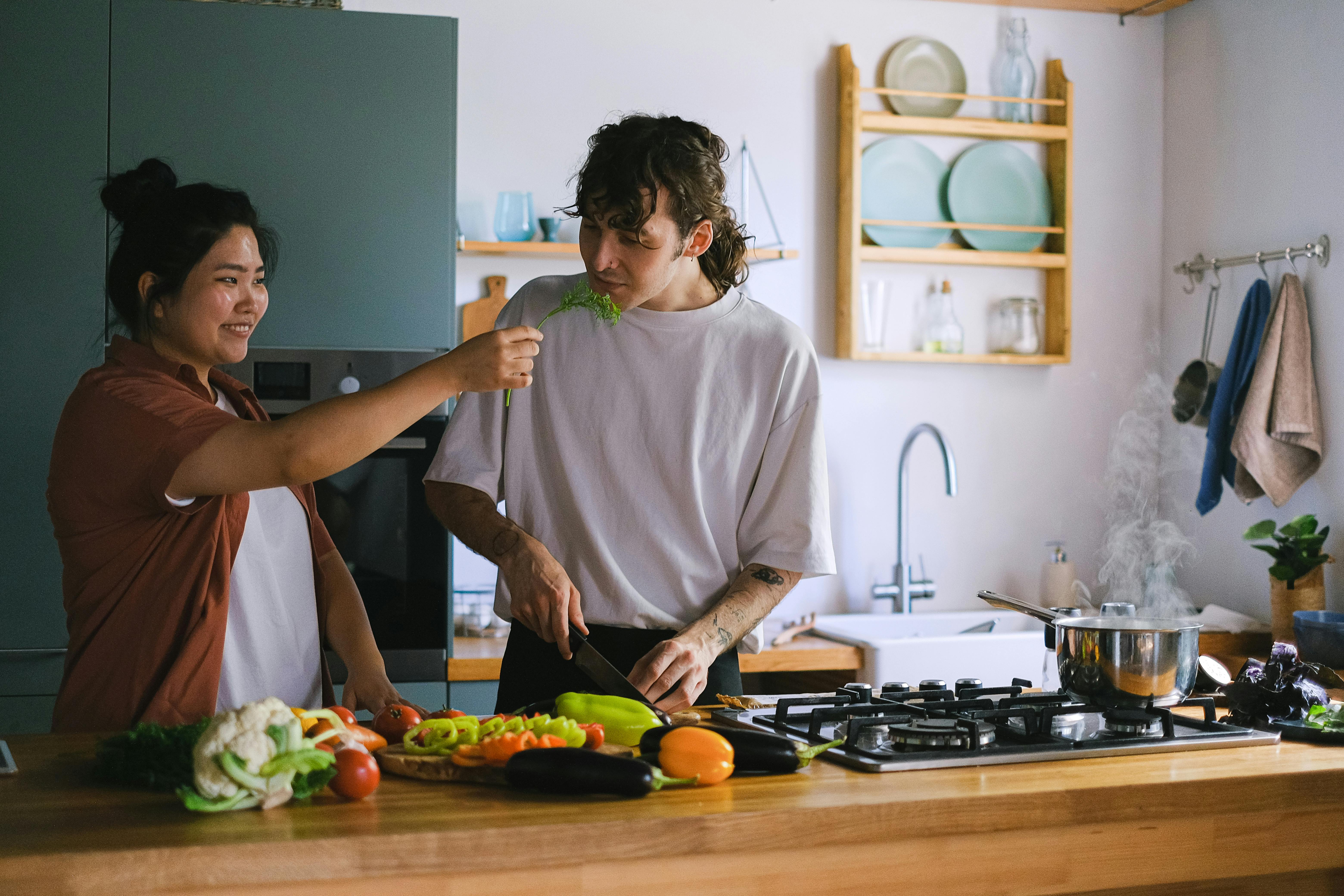 Man in White Crew Neck T-shirt Holding Knife Slicing Vegetable
