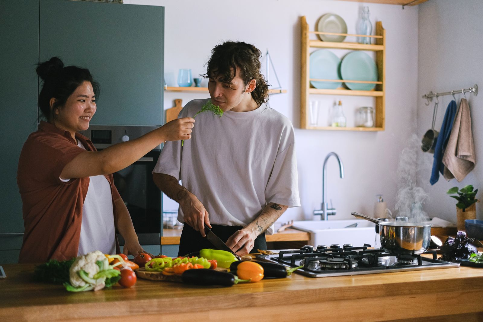 Two people preparing vegetables together in a kitchen