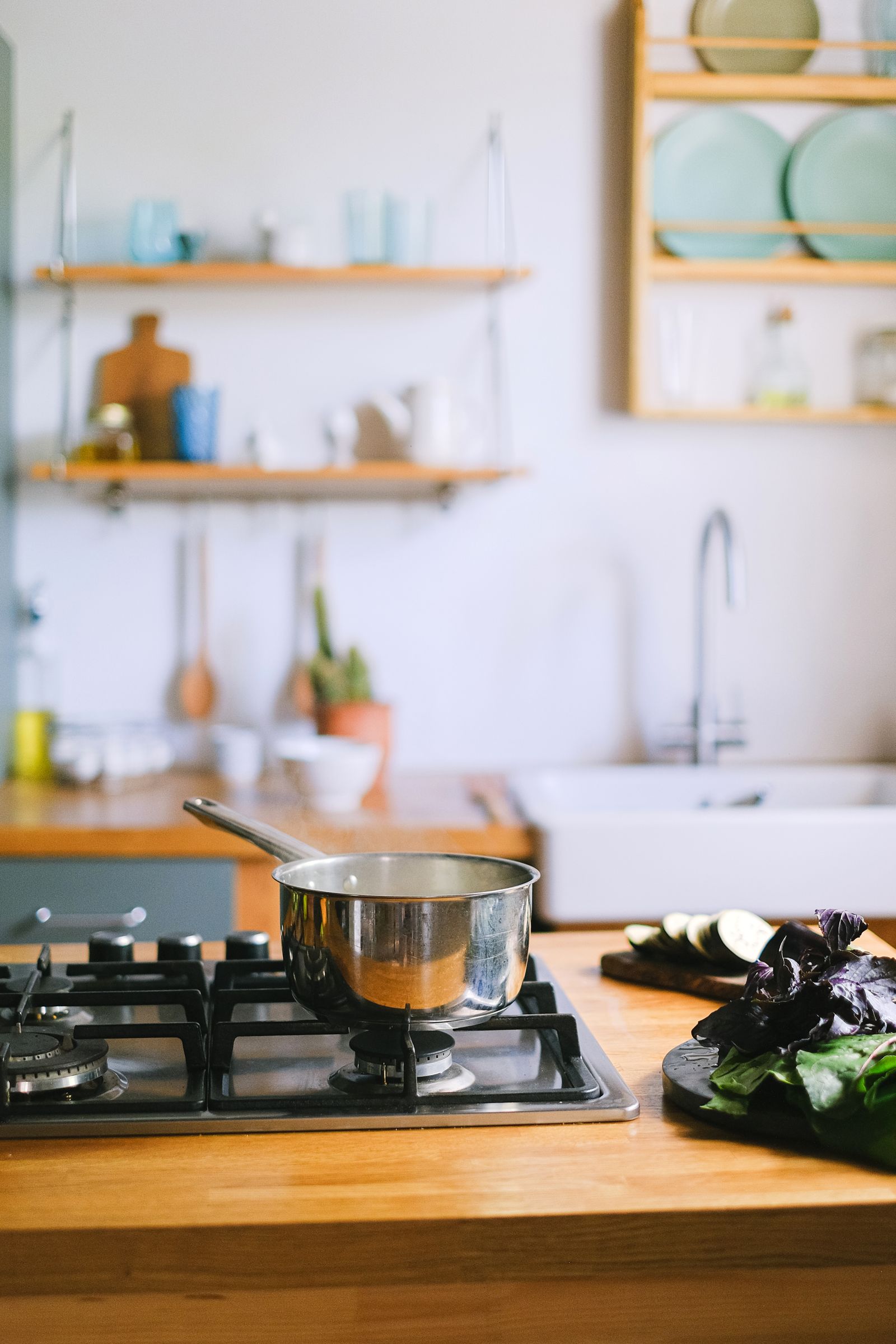 Charming kitchen with a pot on stove and fresh vegetables on the counter.