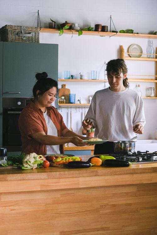 Free A couple preparing food together in a modern kitchen setting. Stock Photo