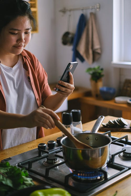 Woman Cooking and Using Phone at the Same Time 