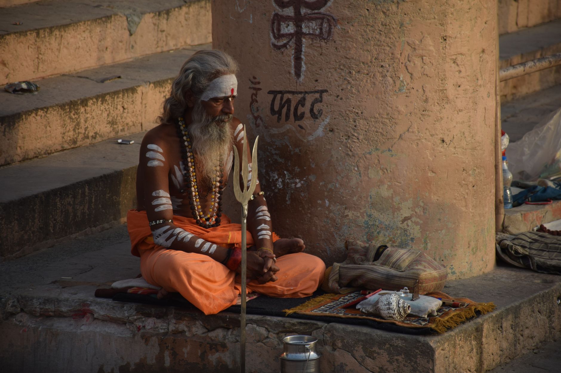 Sadhu meditating in river during sunrise
