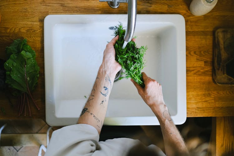 A Person Washing Vegetables