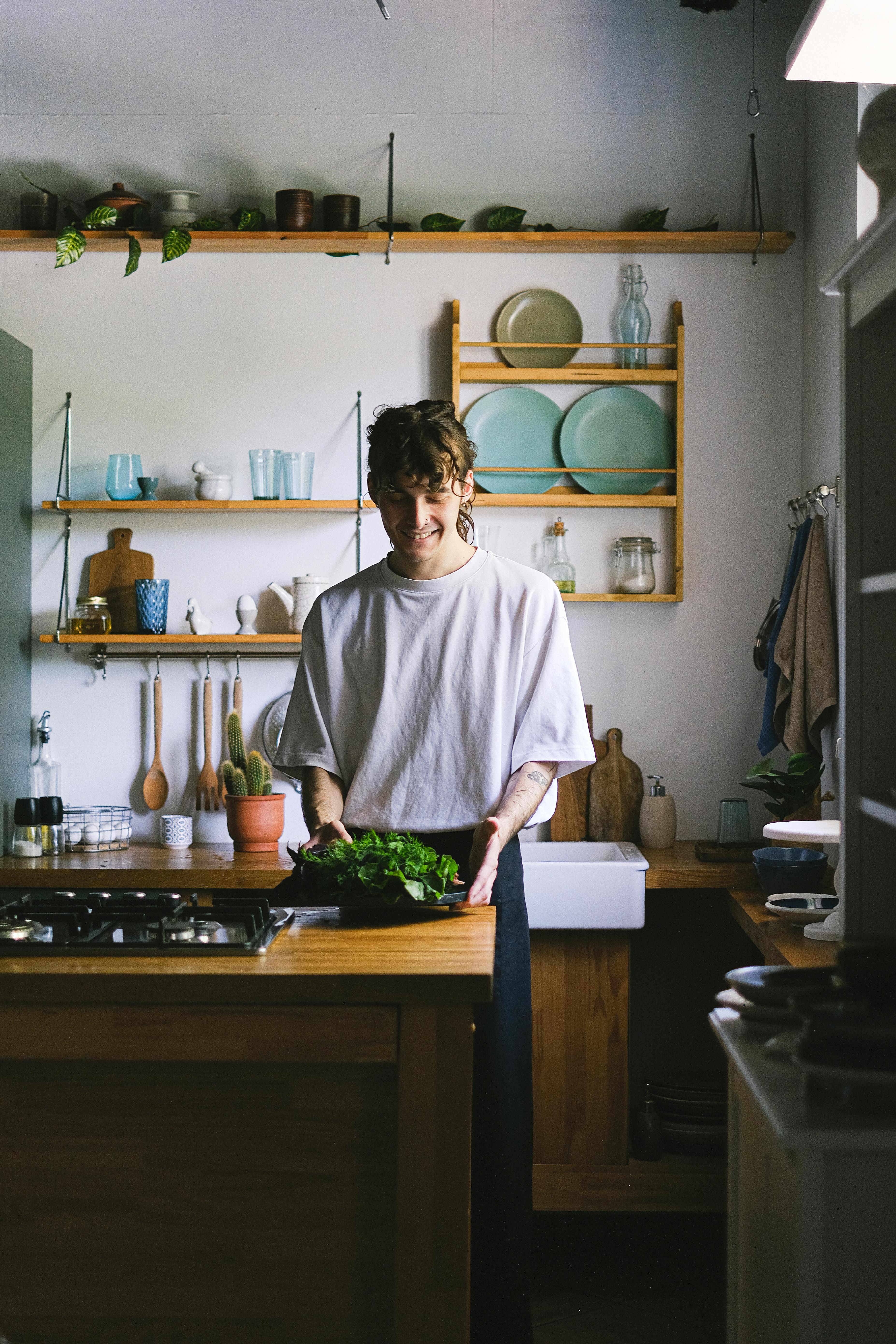 An amateur cook in their home kitchen, focused on preparing a dish with various ingredients around them.
