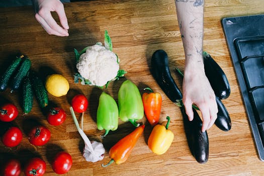 Colorful vegetables including peppers, tomatoes, and eggplants arranged on a kitchen counter.