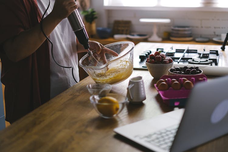 Woman Using Laptop While Cooking